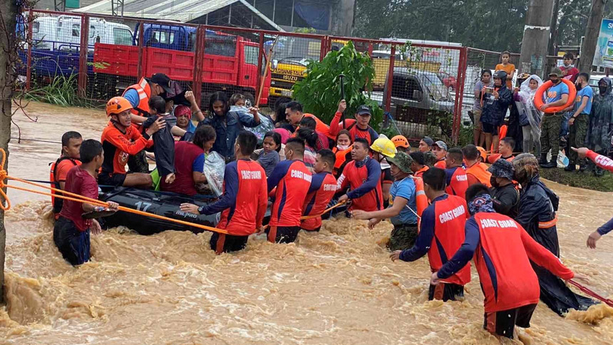 Philippine Coast Guard personnel rescue residents stranded by floods caused by Typhoon Rai in Cagayan de Oro, Philippines, Dec. 16, 2021. The storm has claimed more than 200 lives and Caritas Philippines has appealed for donations to bolster its emergency response. (CNS photo/Philippine Coast Guard handout via Reuters)