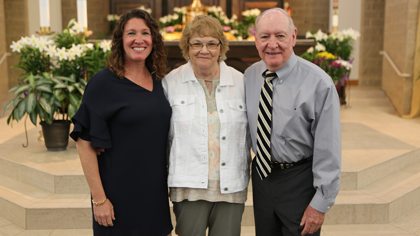 Kelley Champion stands with her parents, who were both middle school teachers as well.