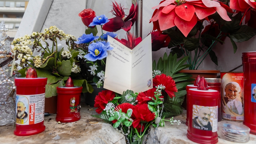 A get-well card for Pope Francis is set among flowers and votive candles at the base of a statue of St. John Paul II outside Rome's Gemelli hospital Feb. 18, 2025. (CNS photo/Pablo Esparza)